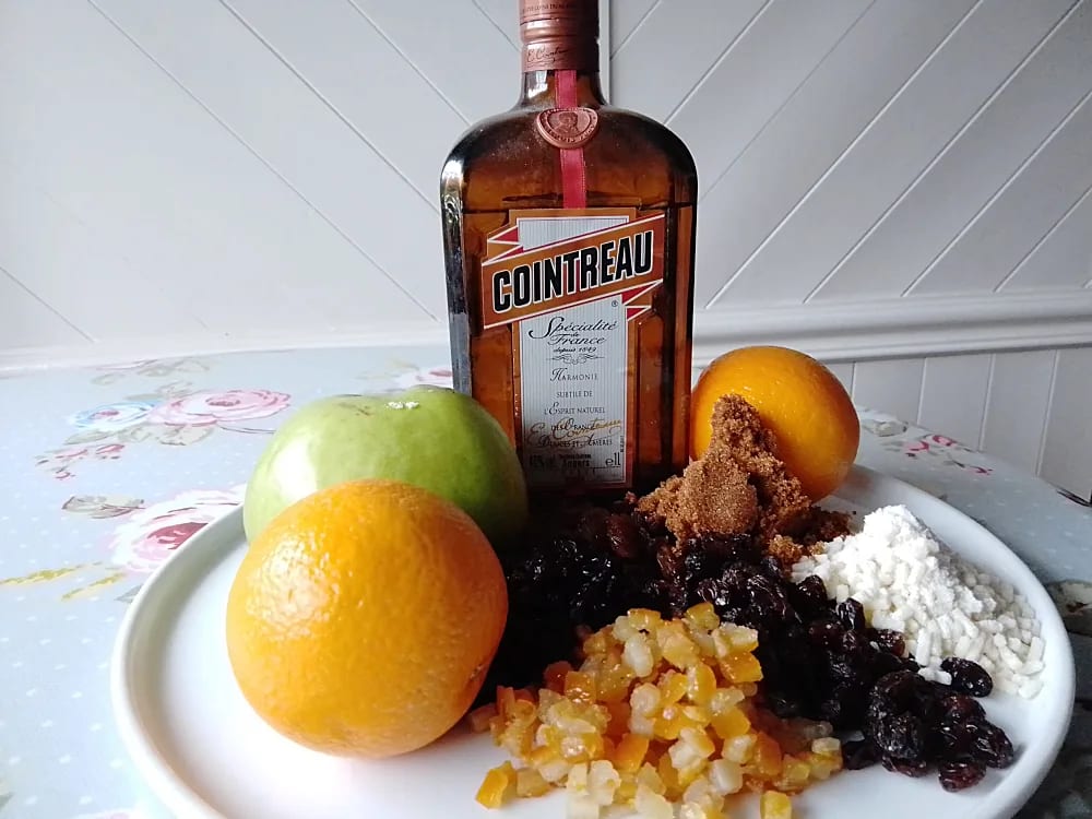 Slow Cooker Orange Mincemeat ingredients on a plate including a bottle of Cointreau